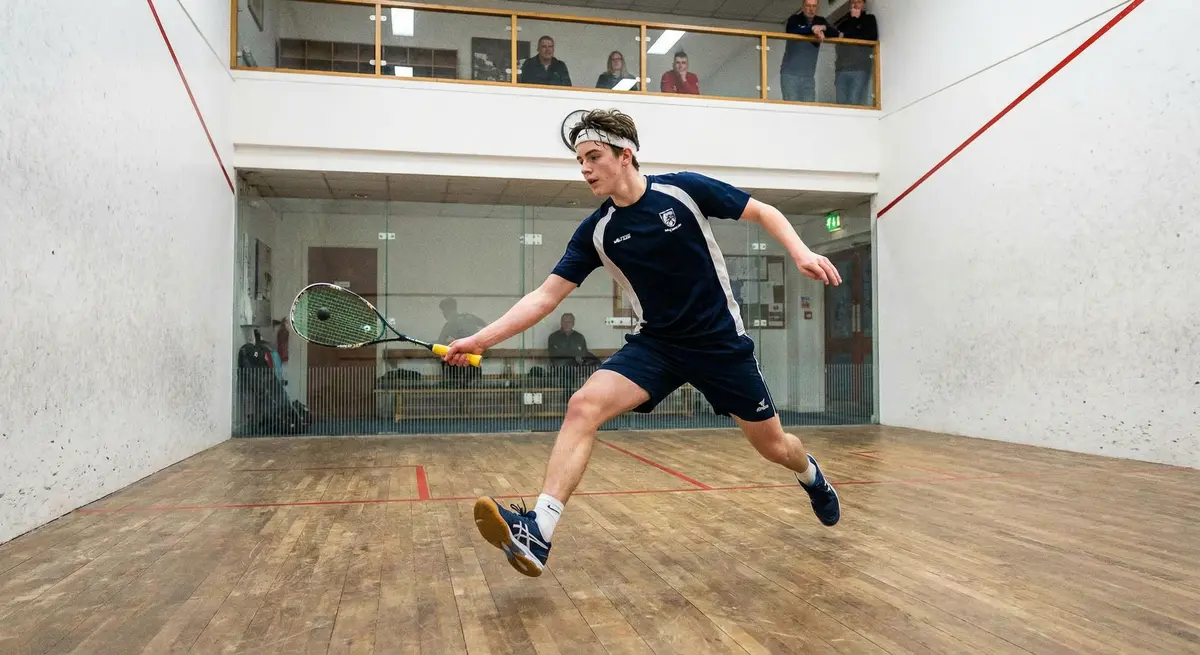 A squash player practicing speed and agility drills on the squash court